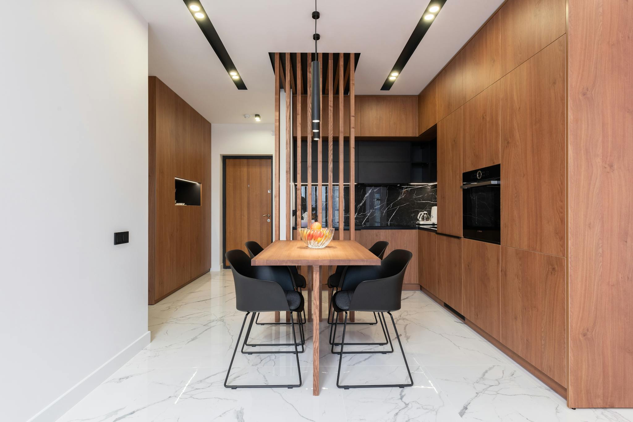 Spacious and stylish kitchen interior with wooden cabinets and dining area.